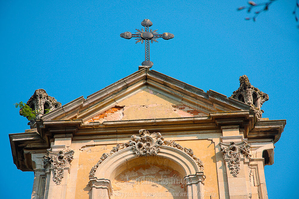 Трикутний фронтон костелу в Годовиці, прикрашений кам’яними вазами, фото 2011 р.