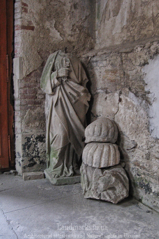 Розбиті фігури святих при вході до костелу в Гусятині